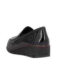 Scarpa nera in pelle senza lacci con una finitura lucida, tacco di media altezza, suola in gomma testurizzata e un dettaglio decorativo sul lato.