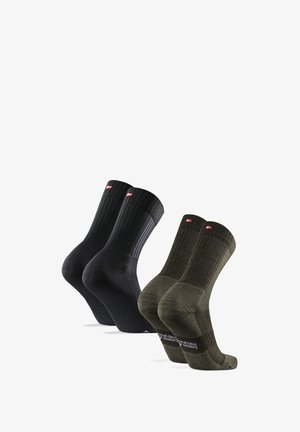 Calzini in cotone con una texture a coste, disponibili in nero e verde scuro. Ogni paio presenta un logo sul risvolto e un accento a contrasto.