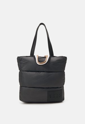 Sac cabas matelassé noir avec deux longues poignées noires et une petite boucle en tissu beige et blanc en haut, étiqueté "BOSS" en bas à l'avant.
