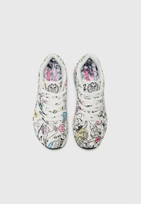Witte sneakers met zwarte, roze en blauwe krabbels, voorzien van veters en een licht getextureerd oppervlak. Ronde neus en gewatteerde kraag.