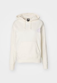 Sweat à capuche crème en tissu doux. Comprend une poche kangourou, une capuche avec cordon et un logo violet sur la poitrine gauche. Poignets et ourlet côtelés.