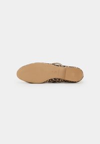 Sandaler med leopardmønster og lys brunt yttersåle, dekorativ stropp og teksturert bunn for grep, som viser en avslappet og åpen design.