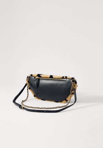 Sac en cuir noir avec un bord en fourrure tacheté beige et noir, doté d'une fermeture éclair dorée et d'une bandoulière en chaîne détachable. Texture lisse avec une forme structurée.