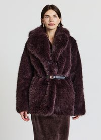 Giacca in pelliccia sintetica viola profondo e morbida con ampio colletto, vita con cintura e due bottoni frontali. Superficie testurizzata e soffice con un aspetto lussuoso.