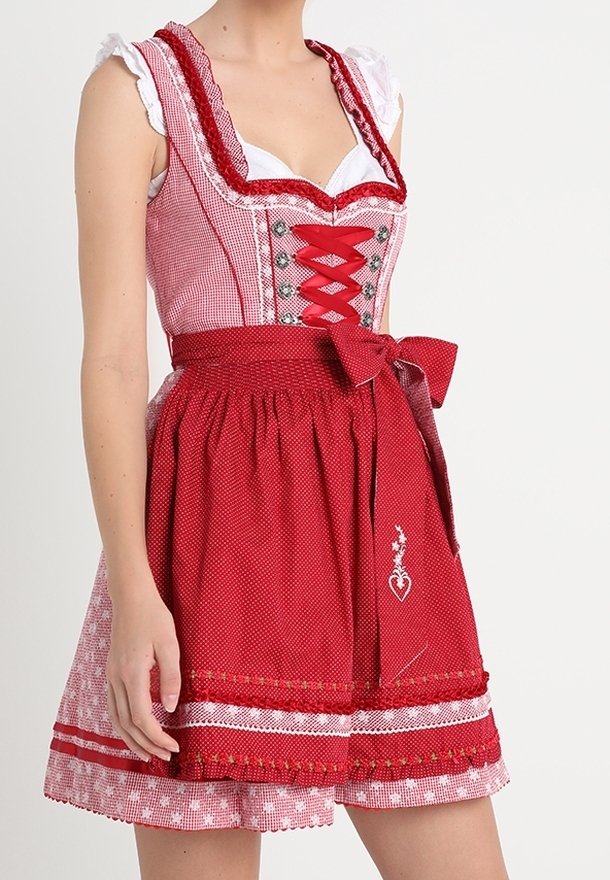 Dirndl à carreaux rouges et blancs avec un corsage à lacets, un nœud à la taille et un détail de cœur brodé sur la jupe. Présente un col à volants.