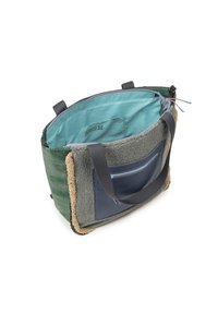 Bolso tote con un exterior de diseño verde, ribete de forro de gris y bolsillo azul marino. Interior azul claro y asas grises. Cierre de cremallera.