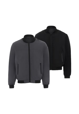 Deux vestes décontractées à fermeture éclair sans col, une gris foncé devant et une noire derrière, toutes deux avec des poches latérales et des poignets côtelés.