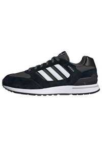 Chaussure de sport en daim noir et en maille avec trois rayures blanches sur le côté, accents synthétiques et une semelle intermédiaire blanche, conçue pour le confort.
