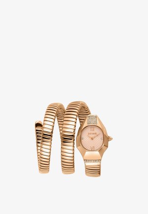 Montre bracelet spirale en or rose avec un cadran rond texturé, des chiffres romains et des cristaux décoratifs sur le boîtier et aux extrémités du bracelet.