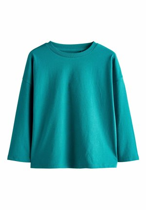 Petrolfarbenes langärmliges Oberteil aus Baumwolle mit rundem Ausschnitt. Mit überschnittenen Schultern und lockerem Schnitt. Glatte Textur und ohne Muster.