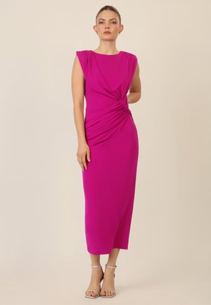 Fuchsia Midi-Kleid mit gerafftem Detail an der Taille, ärmellosen Design und glattem Stoff. Getragen mit silbernen Riemchensandalen.