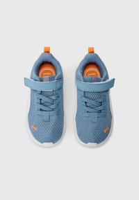 Baskets en mesh bleu avec une semelle blanche, présentant des accents orange et une sangle Velcro. Forme arrondie, surface texturée et détail de logo.