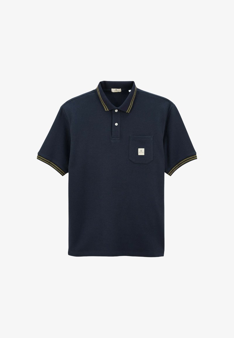 Polo shirt bleu marine en tissu texturé avec une patte de boutonnage à trois boutons, une poche sur la poitrine gauche et un col et des manches accentués de jaune.