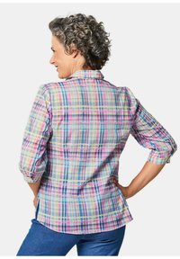 Camicia a quadri con colletto nei colori pastello, con maniche corte arrotolate, caratterizzata da una combinazione di blu, rosa e giallo. Tessuto morbido con spacchi laterali.