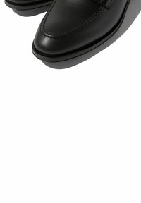 Zwarte leren instappers met een gepolijste afwerking, een spitse neus en een lage rubberen zool. Voorzien van gestikte details langs de randen.