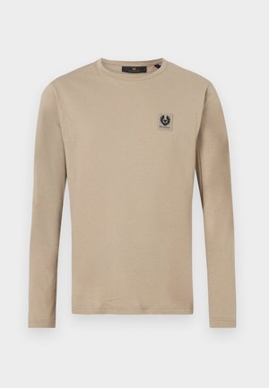 Beige long-sleeve T-shirt made of soft fabric, featuring a square logo patch on the left chest and a crew neckline.