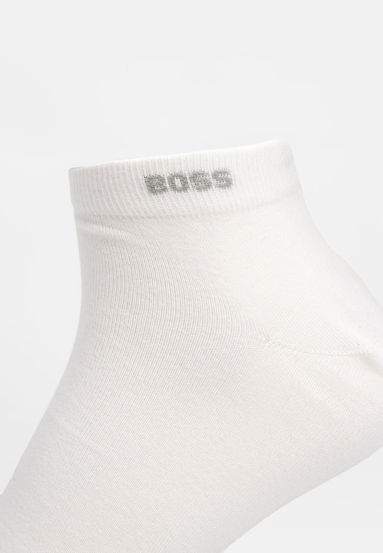 Witte enkelkous van een zachte katoenmix, met een geribbelde bovenrand en subtiele grijze "BOSS" logo nabij de bovenkant. Glad materiaal over het hele oppervlak.