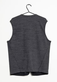 Tmavě šedá pletená bezrukávová vesta s texturovanými bočními panely visící na černém ramínku na bílém pozadí.