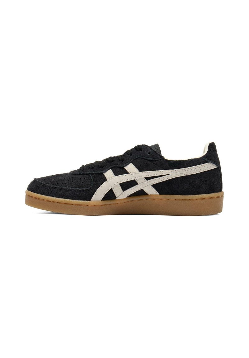 Black suede sneaker with white accents, featuring a low-top design, rubber gum sole, and perforated detailing on the toe box.