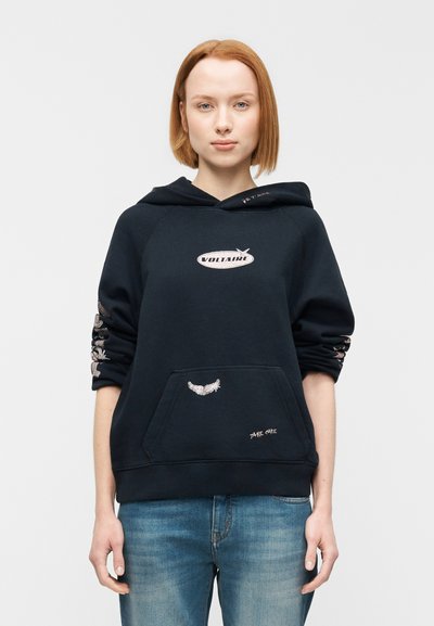 Black hoodie with a kangaroo pocket and embroidered details. Features the word "VOLTAIRE" and decorative accents on sleeves. Soft fabric.