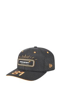 Czarna czapka z wzorem diamentowym, pomarańczowymi akcentami i metką "Zespół Formuły 1 McLaren". Na przodzie wyświetla numer "81" w pomarańczowym kolorze.