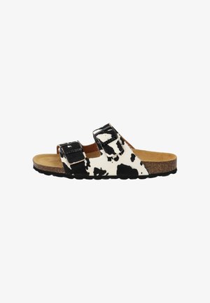 Open-toe sandal with two adjustable black buckles, black and white cow print straps, cork footbed, and black sole.