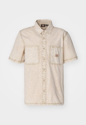 Camicia beige a maniche corte con chiusura a bottoni, due taschini sul petto, dettagli di cucitura visibili e colletto classico.