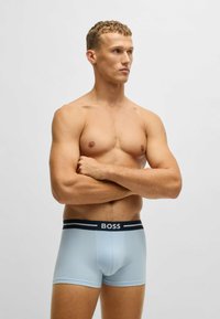 Light blue boxer briefs with a dark waistband featuring "BOSS" text. Soft fabric, fitted design, and medium-length legs.