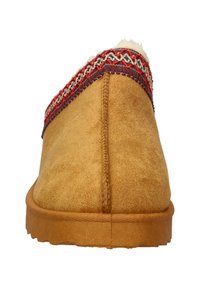 Suede slip-on shoe in tan with a textured surface; features a decorative band in red and gold woven patterns along the upper edge.