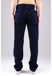 Marineblaue Denim-Jeans mit geradem Bein, Kupfernieten und zwei Gesäßtaschen. Mit einem Markenpatch am Bund.