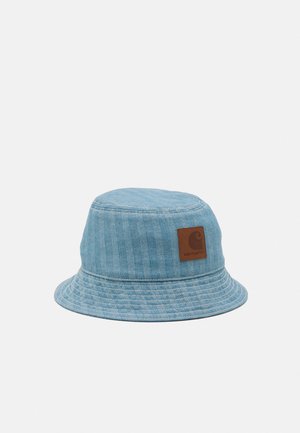 Bob en denim bleu clair avec bord cousu et écusson carré brun avec logo sur le côté.