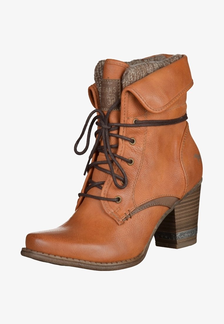 Botte cheville en cuir fauve avec talon empilé, lacets marron, revers plié et doublure en laine visible en haut.