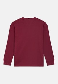 Burgundia puuvillane pikakäiseid särk, millel on ümberkaudne kaelus, soonikkoes mansetid ja minimalistlik disain, millel on lihtne selg.