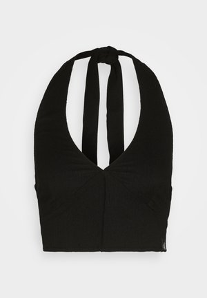 Musta halterneck-toppimainen crop-top, joka on valmistettu teksturoidusta kankaasta. Takana on solmittava nauha ja tiukka siluetti. Ei kuvioita tai lisäkoristeita.