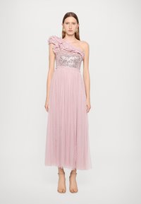 Asymmetrisches pinkes Kleid mit besetztem Oberteil und Rüschendetail an der Schulter. Fließender, transparenter Unterteil mit gepunkteter Textur und geschichteten Stoffen.