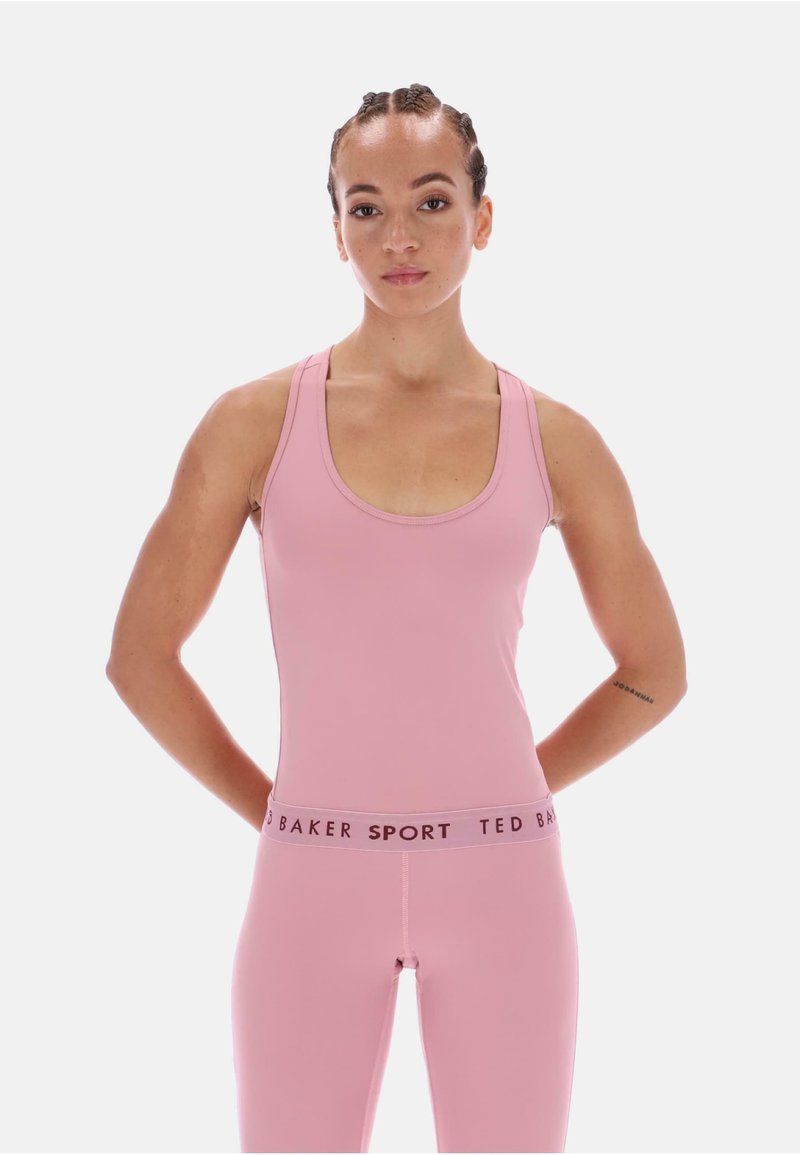 Roza športna majica brez rokavov z širokimi naramnicami in krožnim izrezom, v kombinaciji z usklajenimi leginami, ki imajo kontrastni pas z oznako "TED BAKER SPORT."