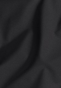 Tissu noir, lisse avec une texture douce, présentant des plis et des ombres subtils, créant une apparence uniforme sans motifs ni accents.
