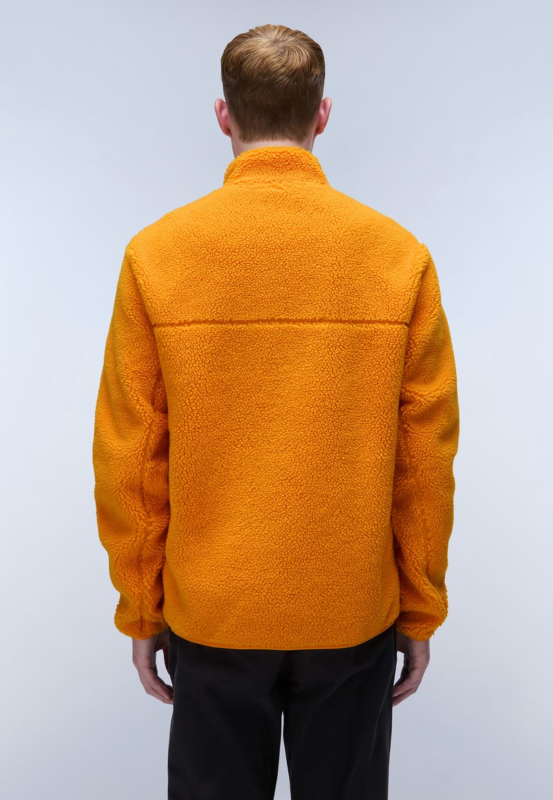 Giacca in fleece arancione con colletto alto, tessuto texturizzato e dettagli di cucitura. Progettata con maniche lunghe e una vestibilità rilassata.