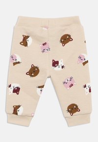 Pantalones de algodón beige con acabado texturizado, decorados con varias ilustraciones de caras de gato en marrón, rosa y blanco. Cintura elástica.