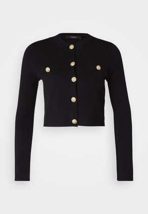 Cardigan scurt negru cu mâneci lungi, având aplicații decorative din nasturi aurii și două buzunare frontale. Fabricat dintr-un material moale și texturat.