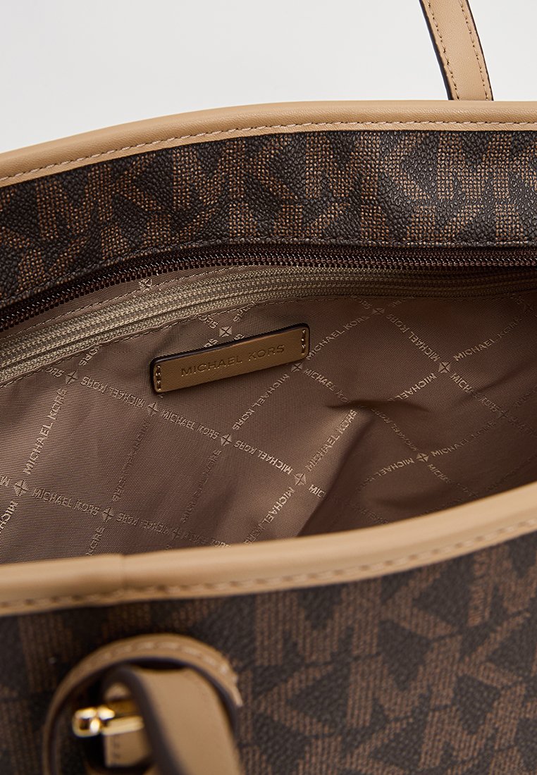 Bruine handtas van leer met een patroon, voorzien van een beige interieur met een ritszak en een reliëf logo-label. Gladde textuur en gestructureerd ontwerp.