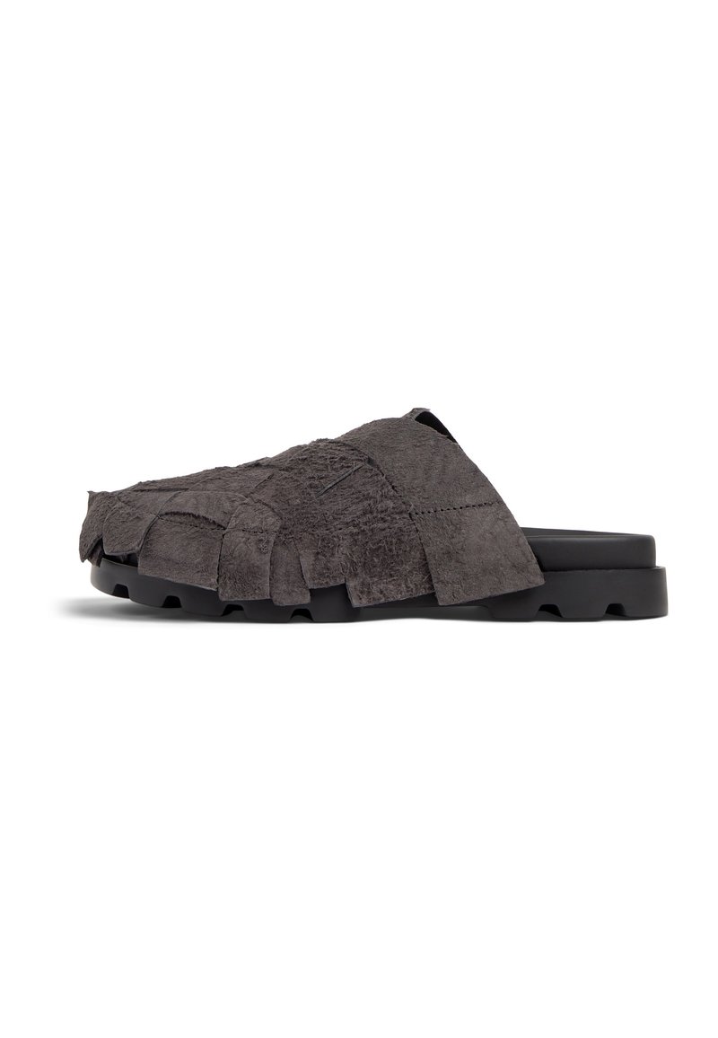 Textured gray suede slide sandal with fringe detailing, black rubber sole, and open back design. Lightweight and casual style.