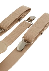 Béžové látkové šle s kovovými klipy, s texturovaným povrchem a kulatým koženým akcentem na jednom konci.
