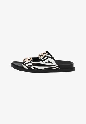 Black and white zebra-striped slide sandal with two adjustable buckle straps and a black sole, featuring a smooth texture and minimal design.