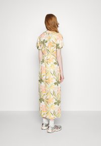 Maxiklänning med ett blommönster i nyanser av rosa, grönt och gult. Korte ärmar, midja med knytning och lättviktigt tyg.