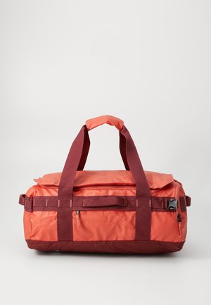 Rectangular orange and maroon duffel bag with dual top handles, front zipper pocket, side buckles, and fabric grip on a white background.