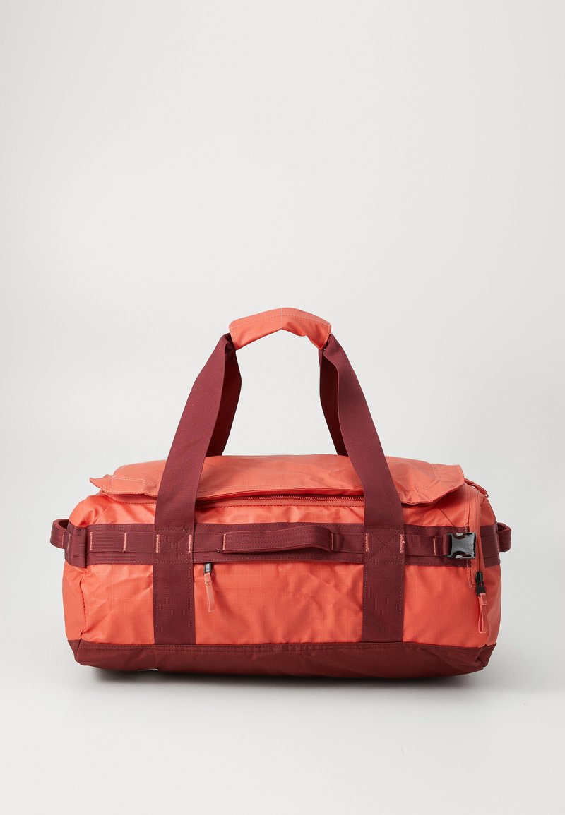 Rectangular orange and maroon duffel bag with dual top handles, front zipper pocket, side buckles, and fabric grip on a white background.