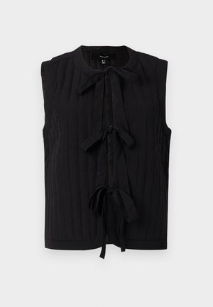 Top sin mangas negro con textura de canalé, escote redondo y detalle de lazo en la parte delantera. Tejido suave con un ajuste entallado.