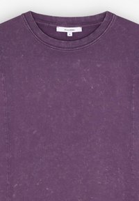 Lilla bomulds T-shirt med rund hals, der har en blød, tekstureret overflade og synlige syninger langs siderne. Størrelseslabel: S.