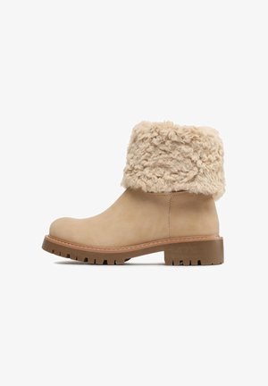 Helle Knöchel-Stiefelette mit dicker Gummisohle und umgeschlagenem beigem Kunst-Lammfellbündchen, Seitenansicht auf weißem Hintergrund.